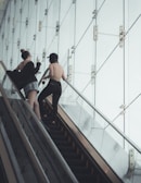 two woman talking on escalator
