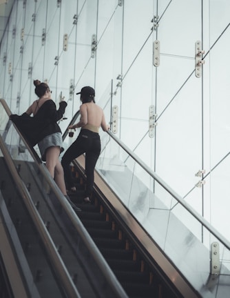 two woman talking on escalator