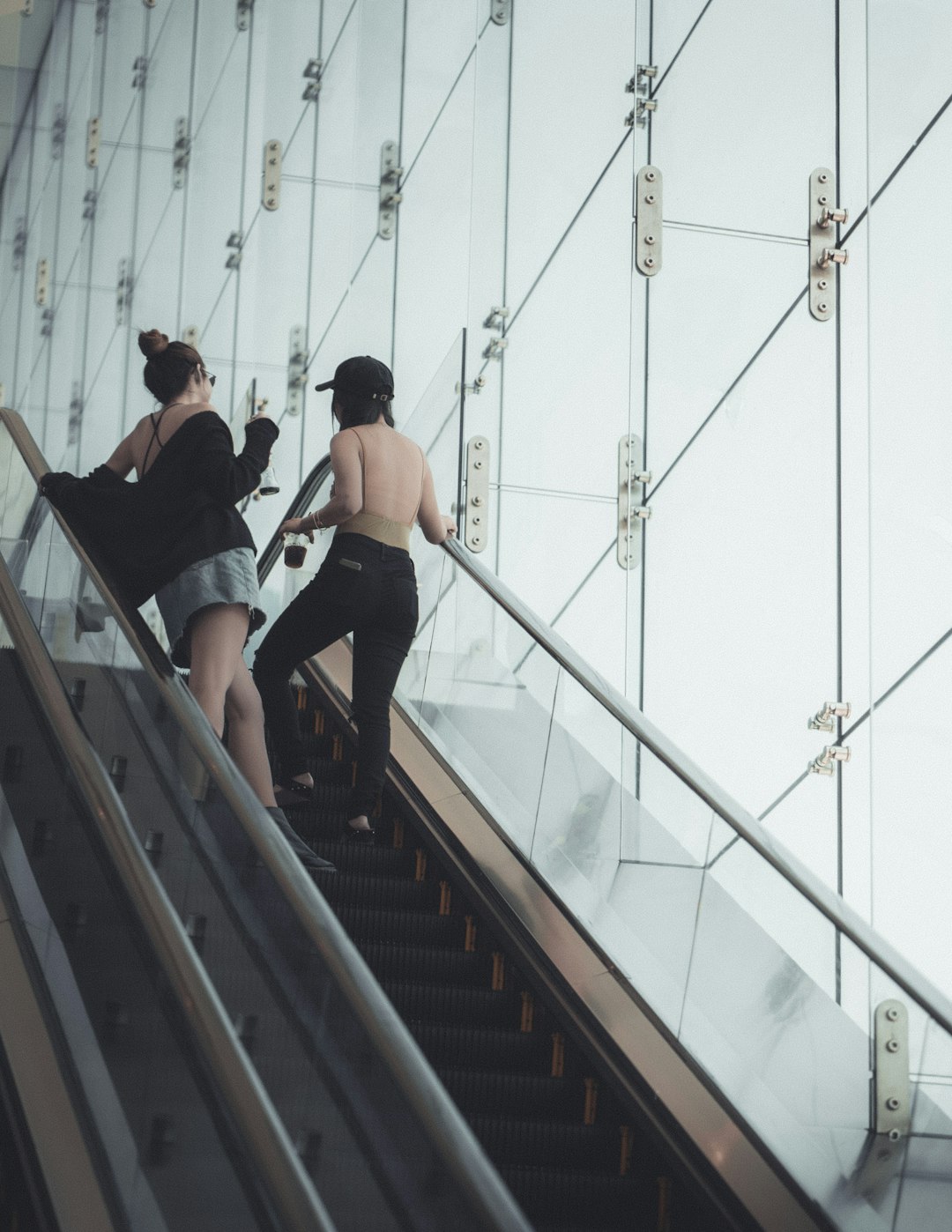 two woman talking on escalator