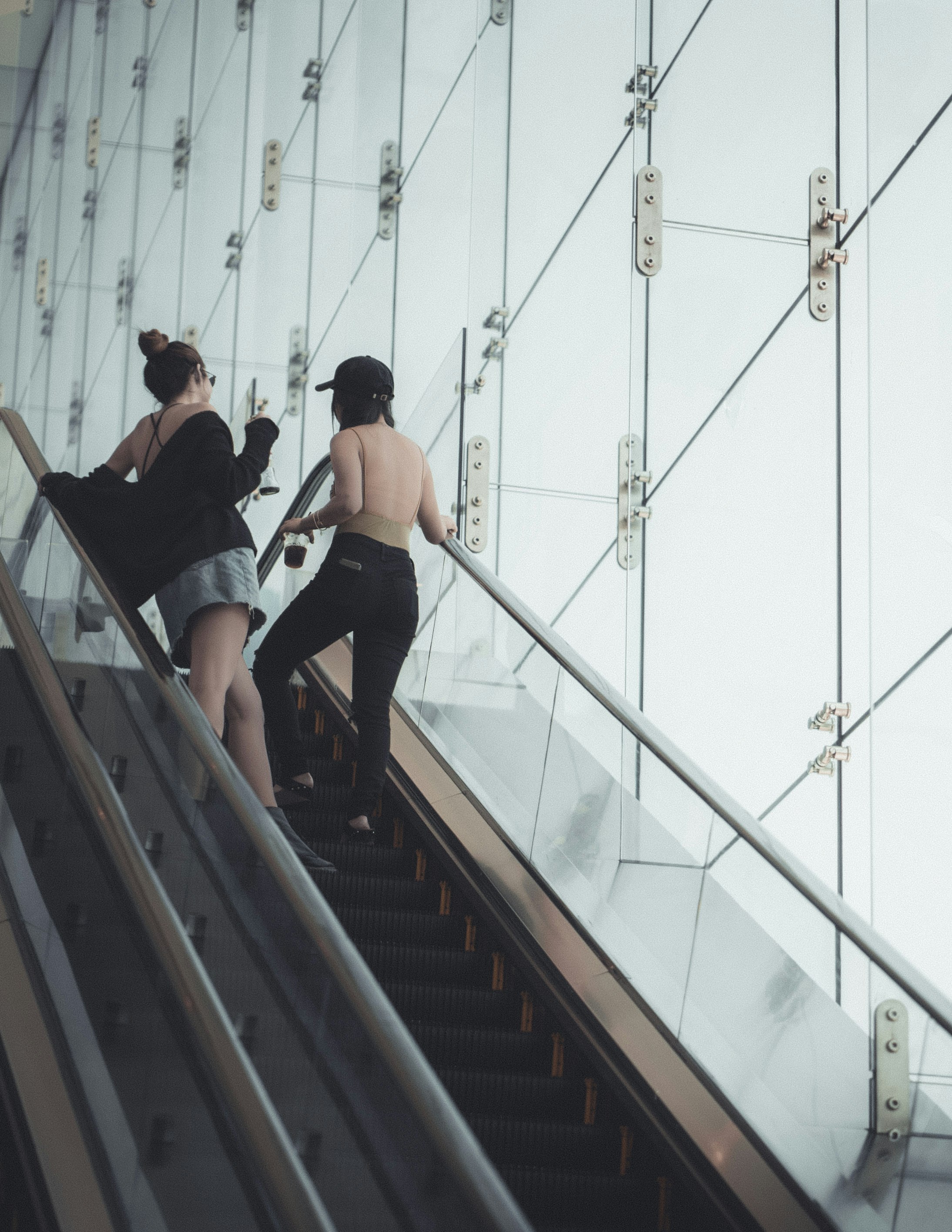 two woman talking on escalator