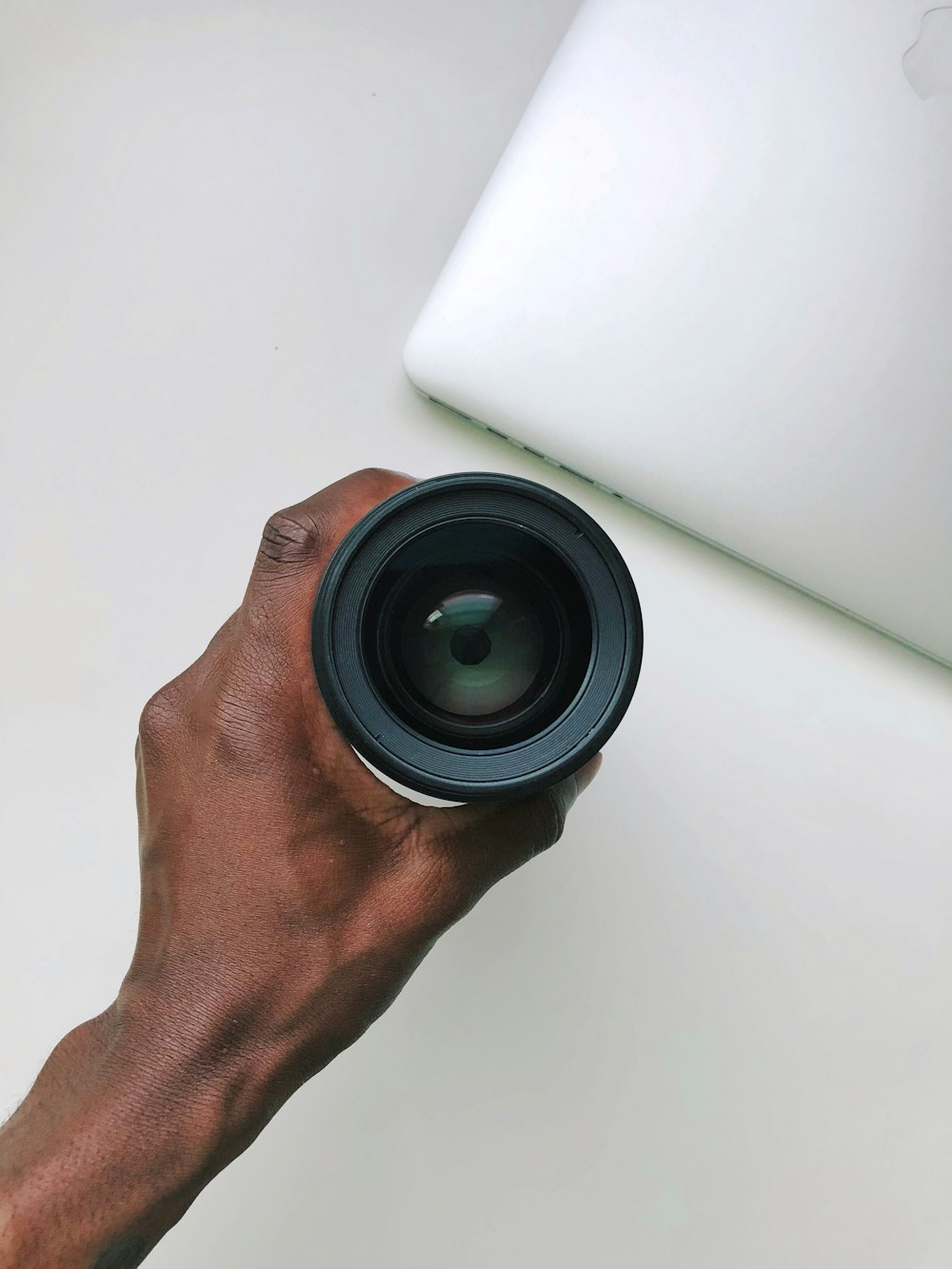 person holding DSLR camera lens