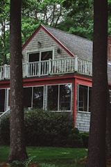 A cozy residential home with bright white siding and red trim freshly painted.
