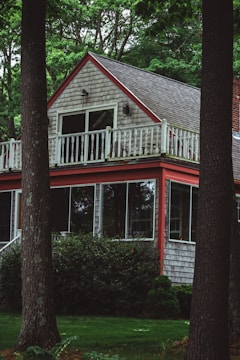 A cozy residential home with bright white siding and red trim freshly painted.