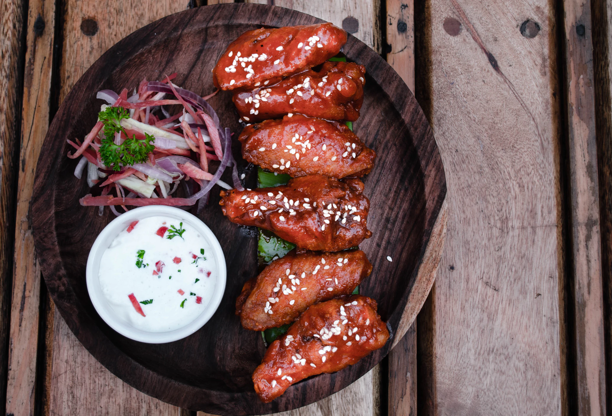 A plate of world famous chicken wings with dipping sauce.