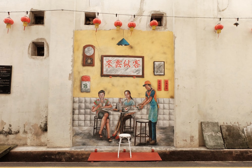 Zwei Frauen sitzen, während der Kellner Gemälde serviert