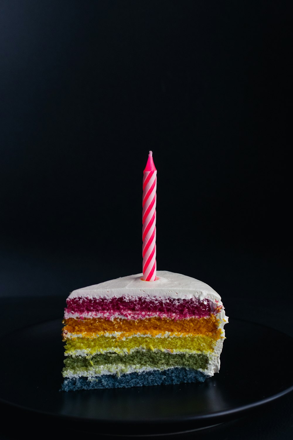 Stück Kuchen mit Kerze oben drauf