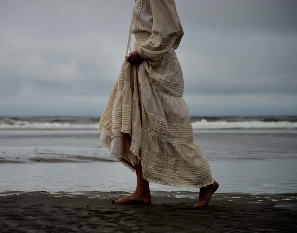 Frau, die am Meeresufer spazieren geht