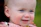 Close-up of a happy baby wearing a soft mint pastel outfit with stars and hearts patterns.