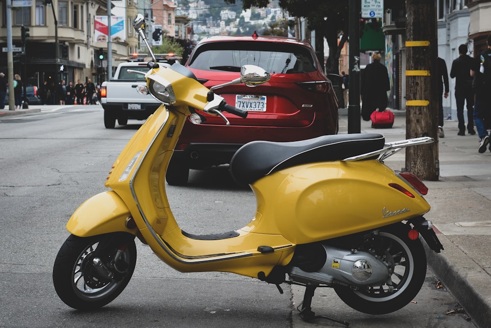 yellow motor scooter parked near sidewalk