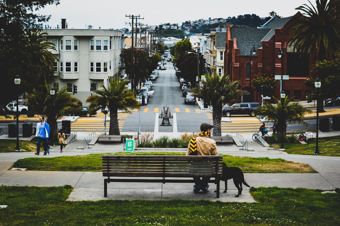 man sitting on bench beside door in park at daytime