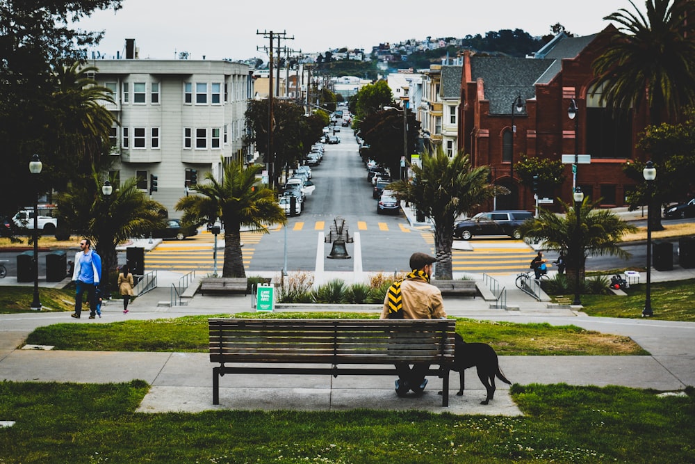 man sitting on bench beside door in park at daytime