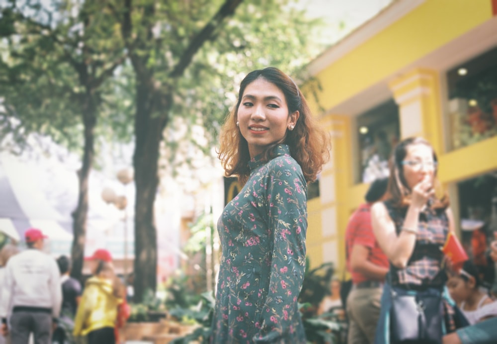 selective focus photo of woman wearing gray and pink floral dress