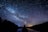 silhouette of person standing under starry sky