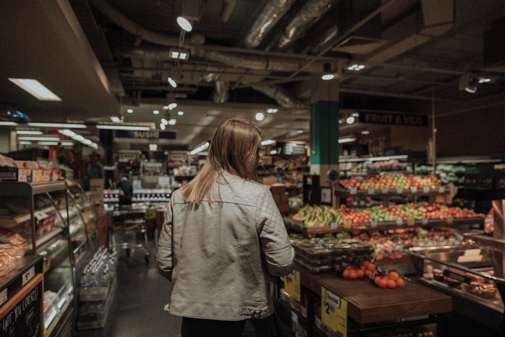 femme debout devant un assortiment de légumes