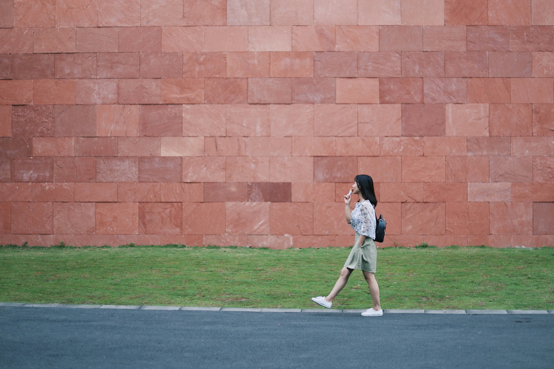 woman walking on asphalt road