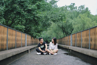 Two people engaged in calm, respectful dialogue in a peaceful park setting.