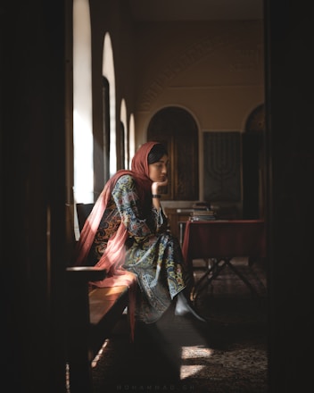 woman sitting on chair while looking down