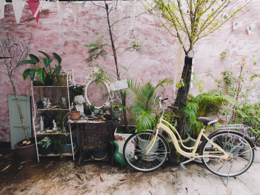 vélo de croisière de plage beige garé à côté de plantes