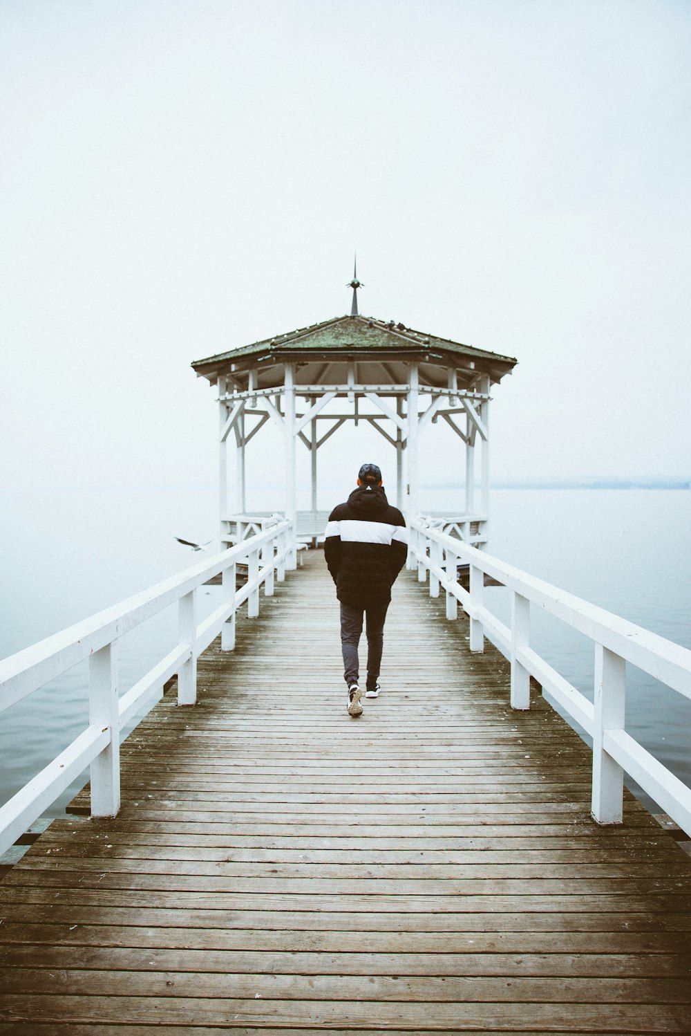 person walking toward cottage on body of water