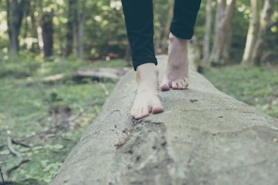 Barefoot walk in a lush green forest with soft sunlight filtering through leaves.