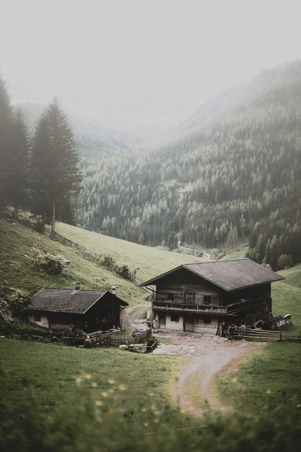 duas casas de madeira marrom perto da montanha e árvores durante o dia
