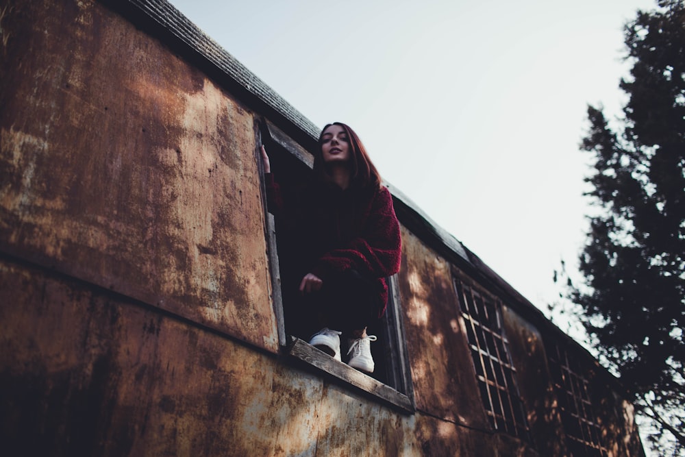 woman on window near tree