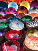 Handcrafted ceramic bowls with playful patterns in bright blues and oranges.