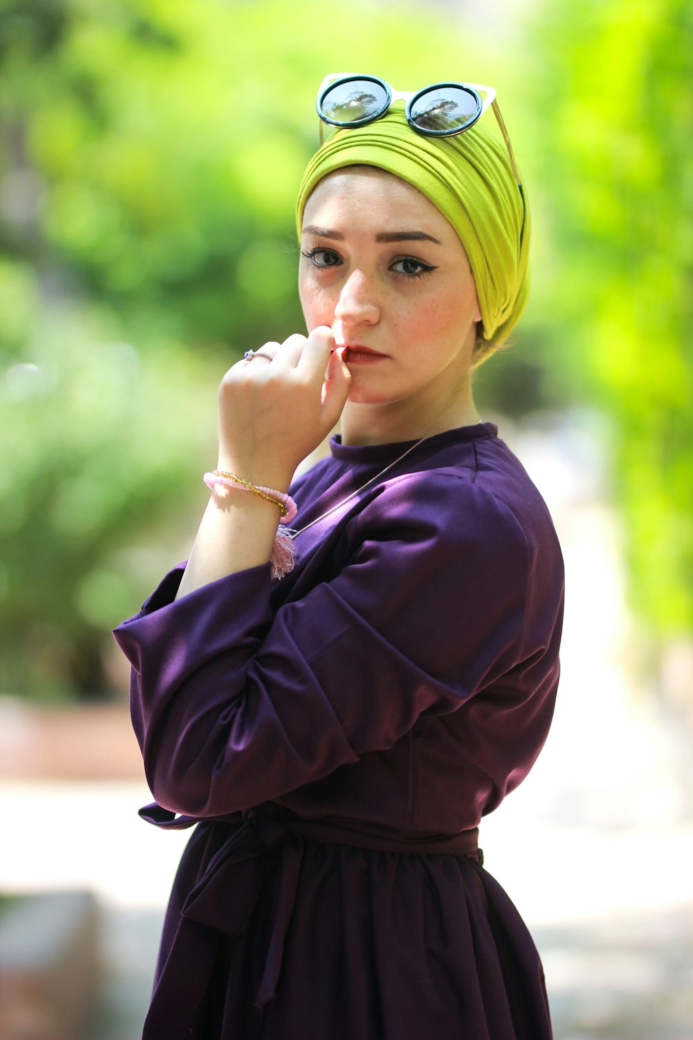 woman wearing purple long-sleeved top holding her lips during daytime