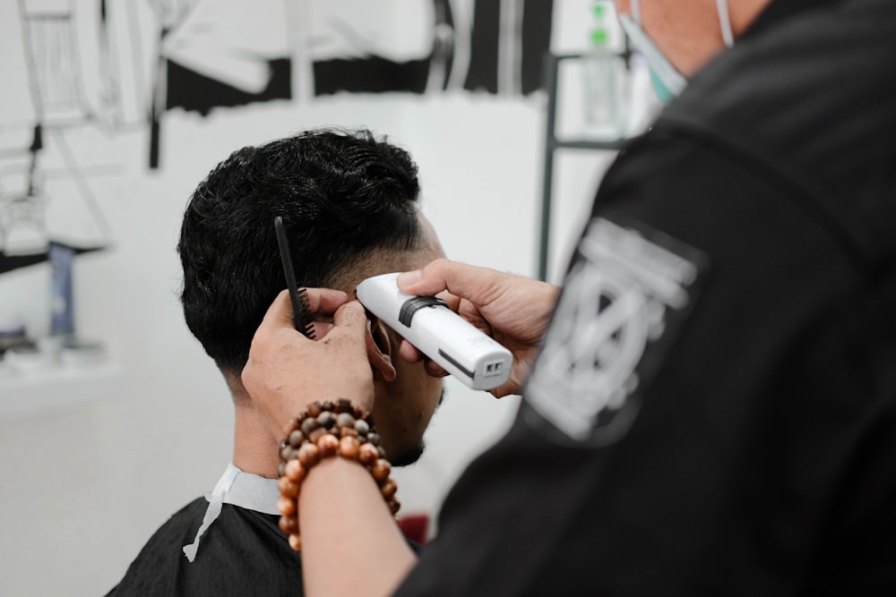 man holding white hair trimmer