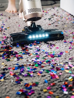 a person using a vacuum to clean a carpet