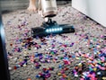 a person using a vacuum to clean a carpet