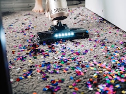 a person using a vacuum to clean a carpet