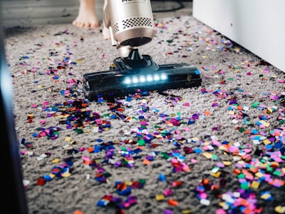 a person using a vacuum to clean a carpet