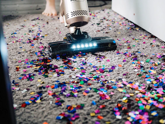 Cleaning professional using a vacuum to clear dust after renovation work.