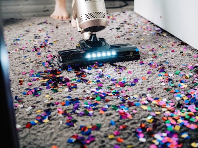 A modern vacuum cleaner in action on a carpet.