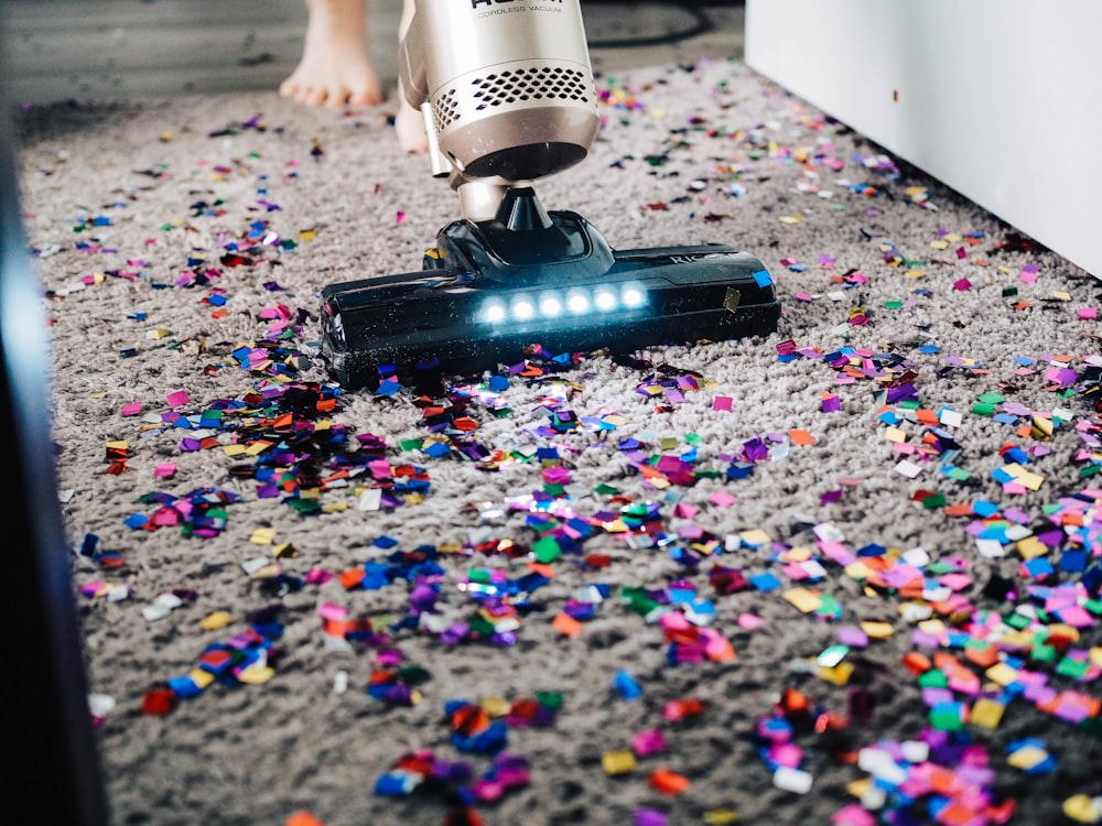 une personne qui utilise un aspirateur pour nettoyer un tapis ;