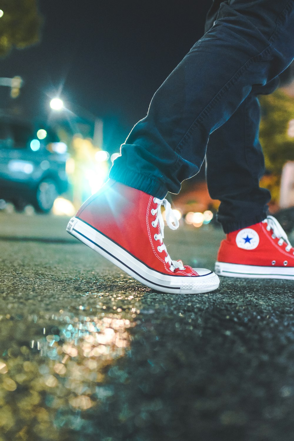 worm's eye view photo of person wearing pair of red Converse All Star sneakers