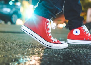 worm's eye view photo of person wearing pair of red Converse All Star sneakers