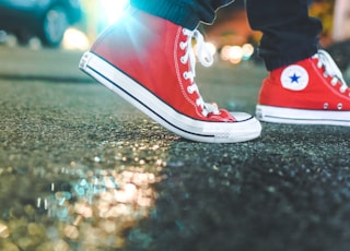 worm's eye view photo of person wearing pair of red Converse All Star sneakers