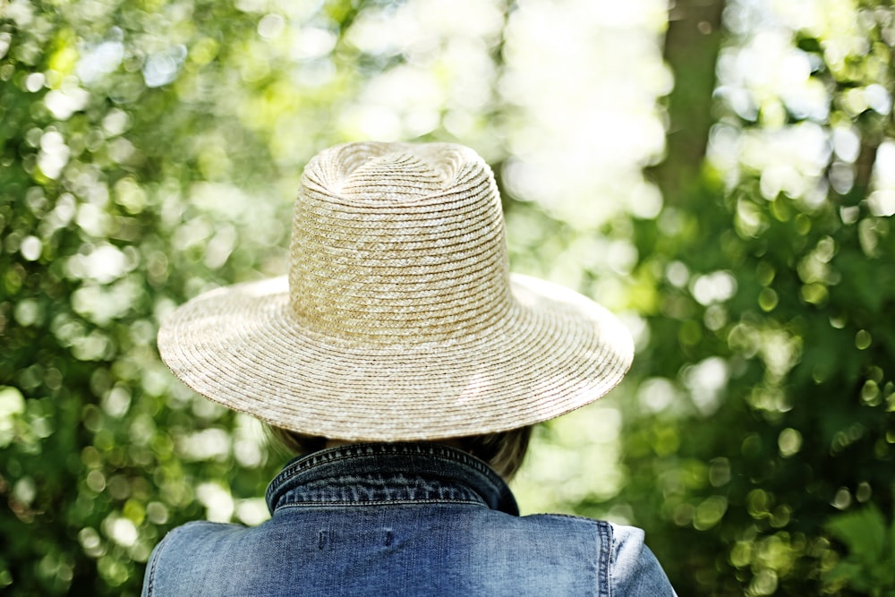a person wearing a hat in front of trees