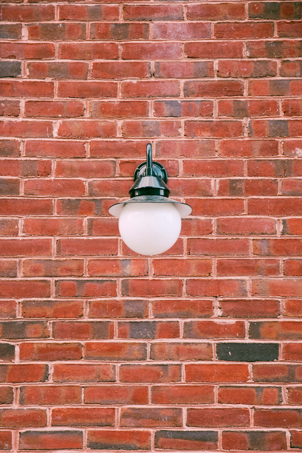 turned-off outdoor light on red bricked wall