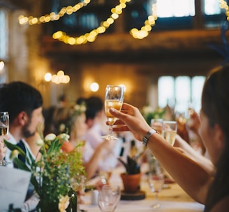 people raising wine glass in selective focus photography