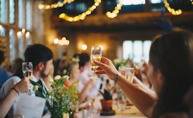 people raising wine glass in selective focus photography