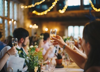 people raising wine glass in selective focus photography