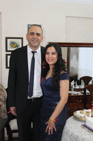 A well-dressed man and woman in formal attire, exuding confidence at a stylish event.