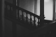 Desaturated shot of a sleek, angular staircase disappearing into darkness.