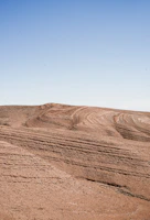 Golden desert dunes under a vast, clear blue sky.