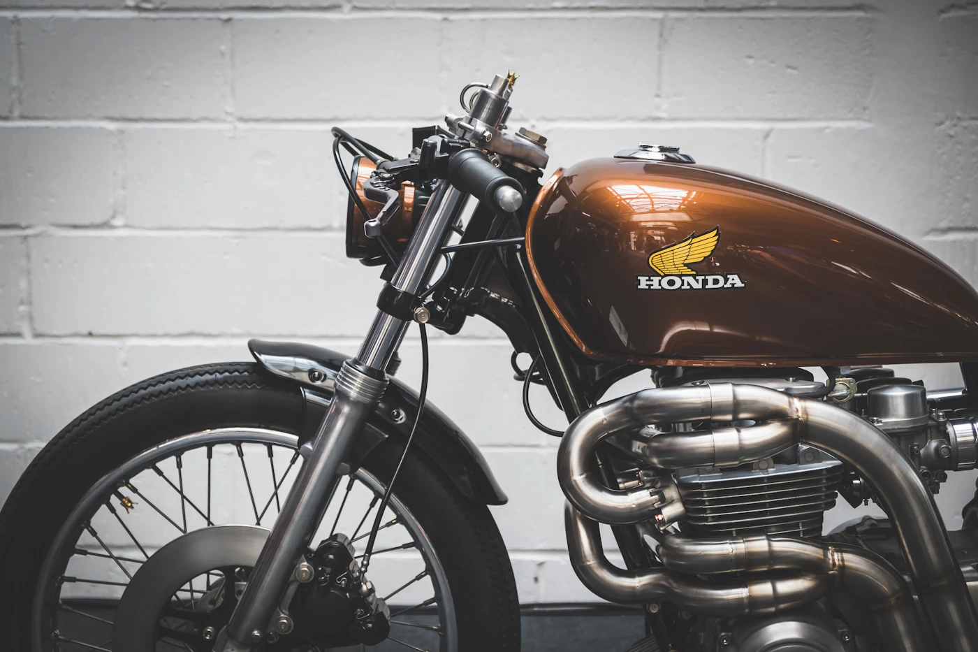 Close-up of a polished Honda fuel tank badge and chrome exhaust