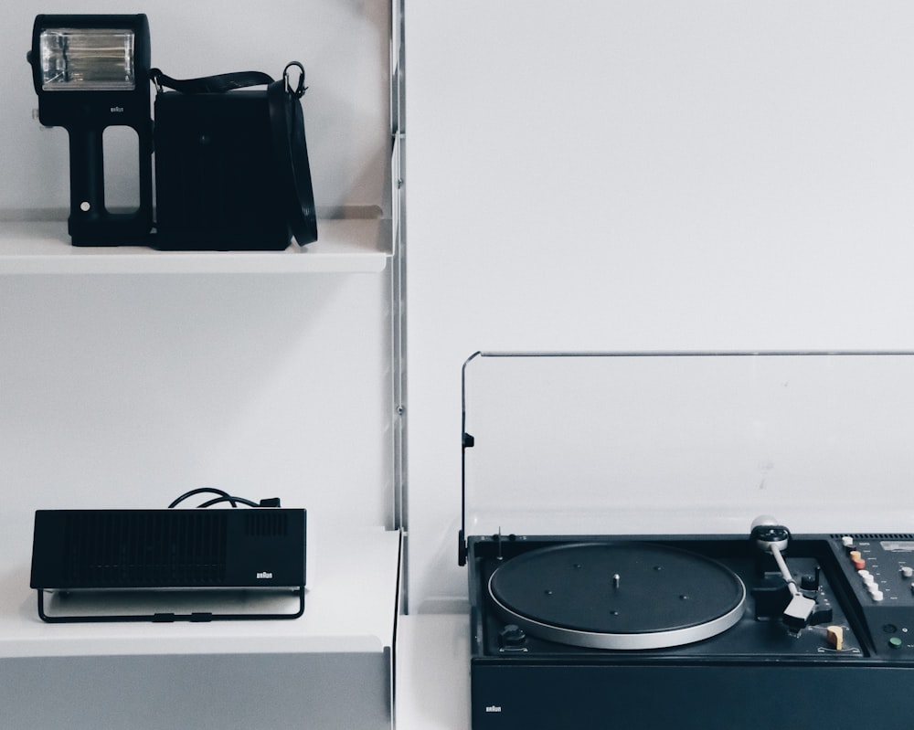 black portable turntable beside black laptop under black camera