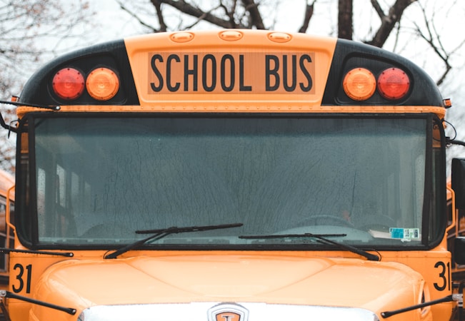 Close-up detail of a yellow school bus, representing CCSD transportation and the steps Clark County parents can take when a bus route runs late